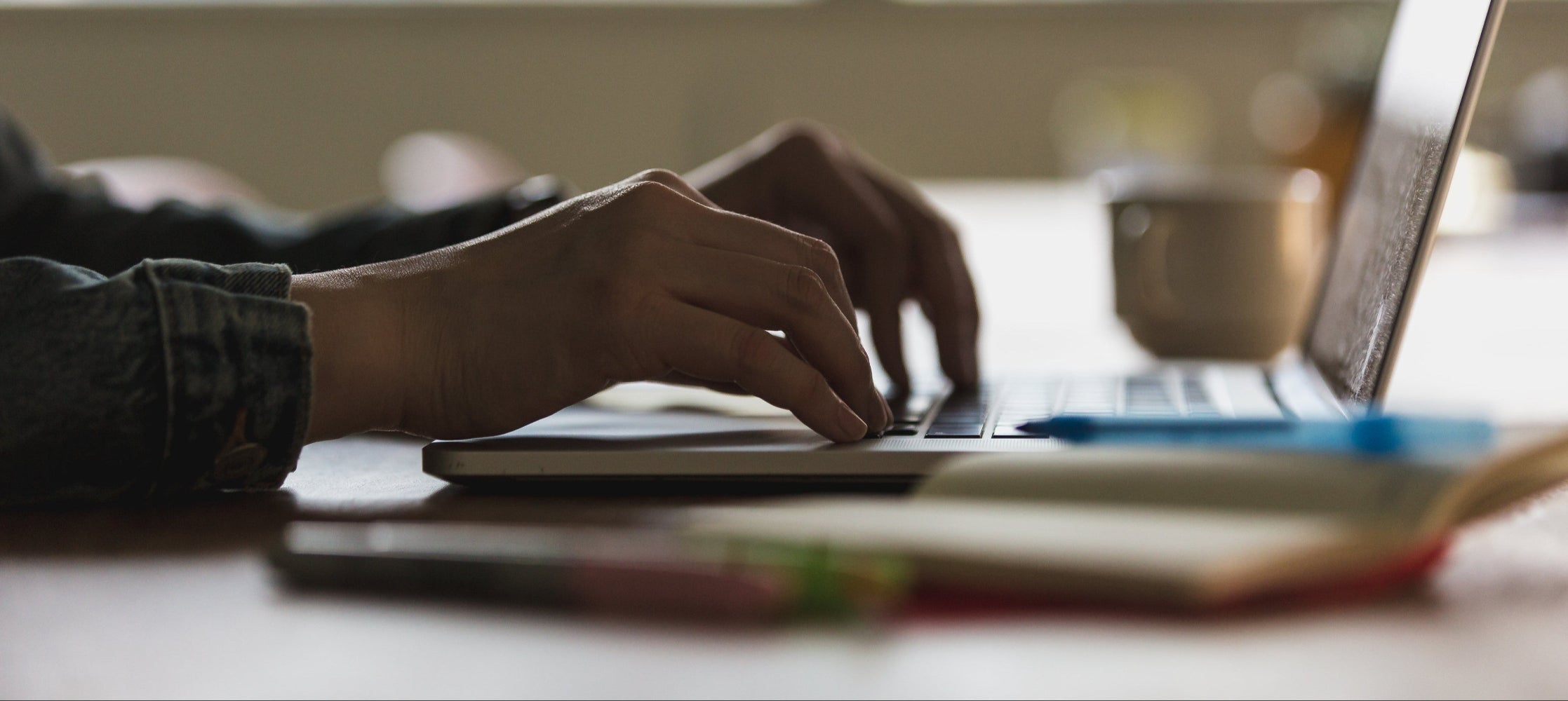 Person typing on a laptop with a blurred background